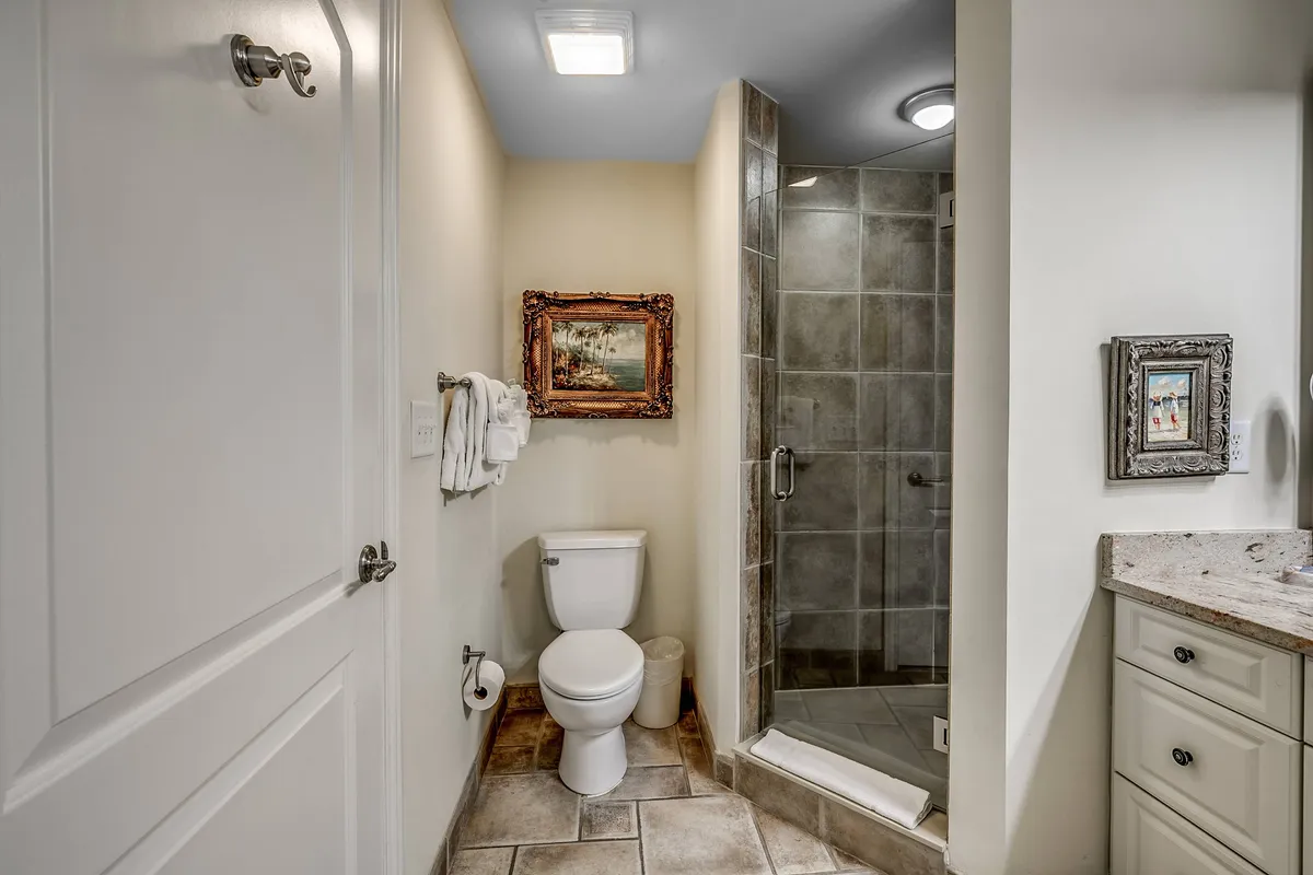 The bathroom image includes a framed painting, spacious shower area, vanity with sink, and elegant finishes. The setting is calm and inviting, emphasizing both practical amenities and a touch of luxury.